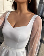 Rochie de mireasa albă din satin cu decolteu și mâneci transparențe din tull.