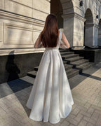 Rochie de mireasa albă lungă din satin elegantă, cu mâneci transparente și cordon detașabil.