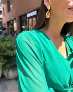 Rochie verde elegantă cu mâneci, drapaj și fermoar la spate.